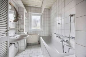 Das Badezimmer ist solide und neutral im Stil der 90er Jahre ausgestattet.