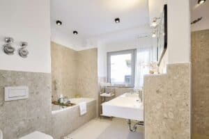 Modernes Masterbad in Naturtönen mit Badewanne und großer offener Rainshower-Dusche