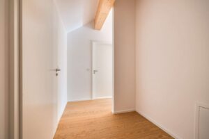 Flur mit beeindruckenden Deckenhöhen bis zu 5 Metern und sichtbarem Holzbalken