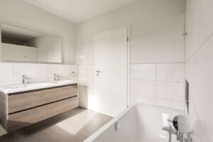 Badezimmer mit Dusche, Badewanne und Doppelwaschtisch