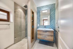 Frisches Design trifft Komfort: Zeitgemäßes Bad mit bodengleicher Regendusche und maßgefertigten Nischen