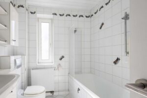 Raumhoch gefliestes Badezimmer mit Wanne und Tageslicht